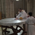 Un servant d'autel essuie le surplus de saint chrême