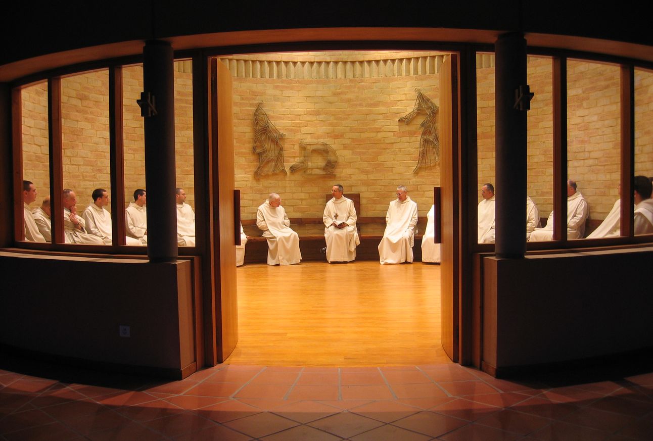 Les frères sont assis en rond dans la salle du chapitre et écoutent le père abbé.