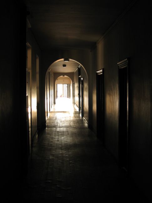 Couloir assombri par l'ombre de la galerie du cloitre et débouchant sur la lumière de la galerie des glaces.