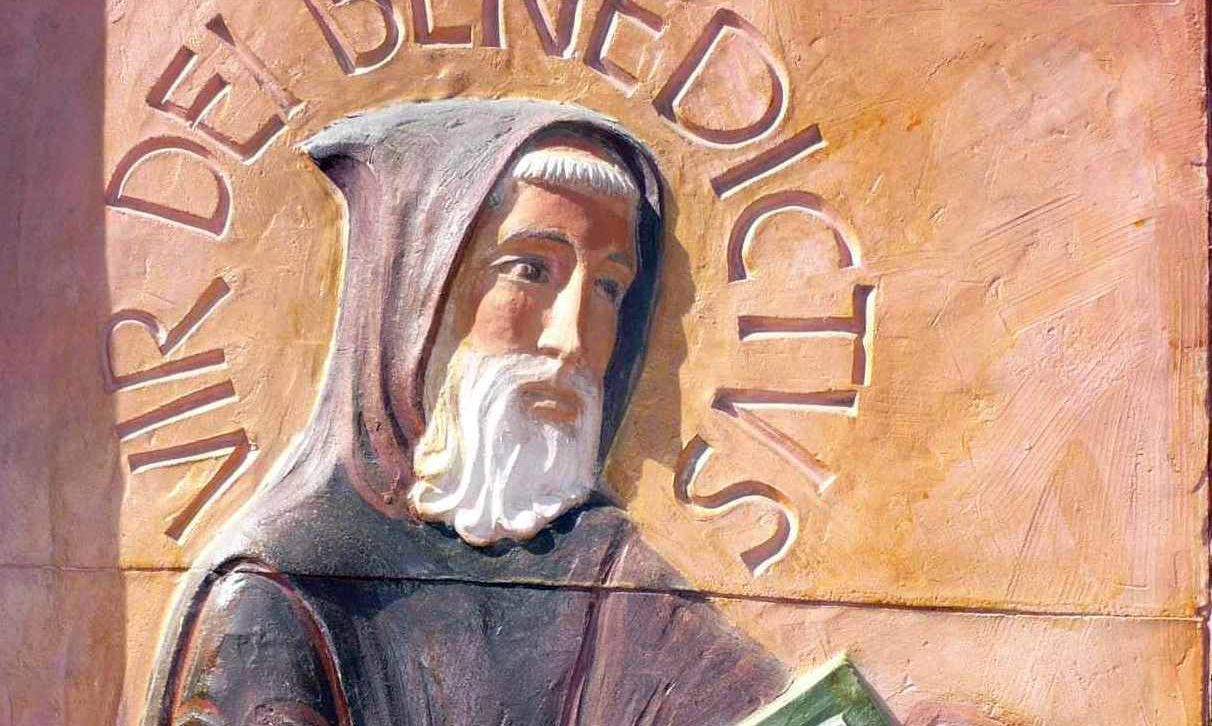 Visage de Saint Benoit sur un bas relief en terre cuite situé à l'entrée de l'abbaye. Barbe blanche et capuchon en tête, il offre aux moines les fruits de sa sagesse et de son expérience rassemblés dans la Règle.
