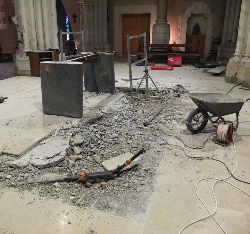 La table de l'autel a été enlevée. Un marteau piquer repose sur les décombres de la marche à moitié défaite.