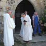 le père abbé applaudit le novice à la sortie de l'église