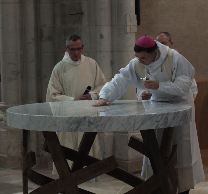 l'évêque répand le saint chrême sur l'autel
