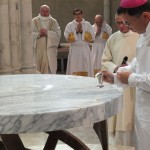 l'évêque verse le saint chrême sur l'autel
