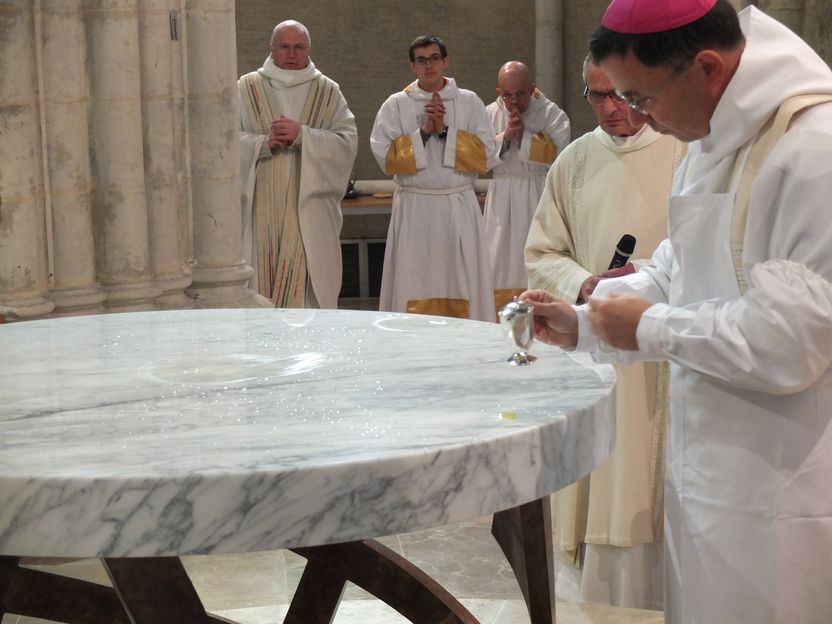 l'évêque verse le saint chrême sur l'autel