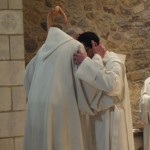 Echange d'une accolade de paix entre le père abbé et le novice
